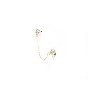 May include: A gold chain earring with a clear, triangular-shaped gemstone at the top and a larger, clear, marquise-shaped gemstone at the bottom.