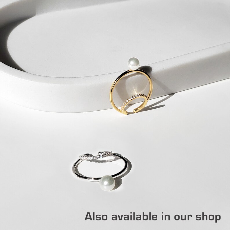 May include: Two gold and silver ear cuffs with a pearl accent. The ear cuffs are adorned with small sparkling stones.