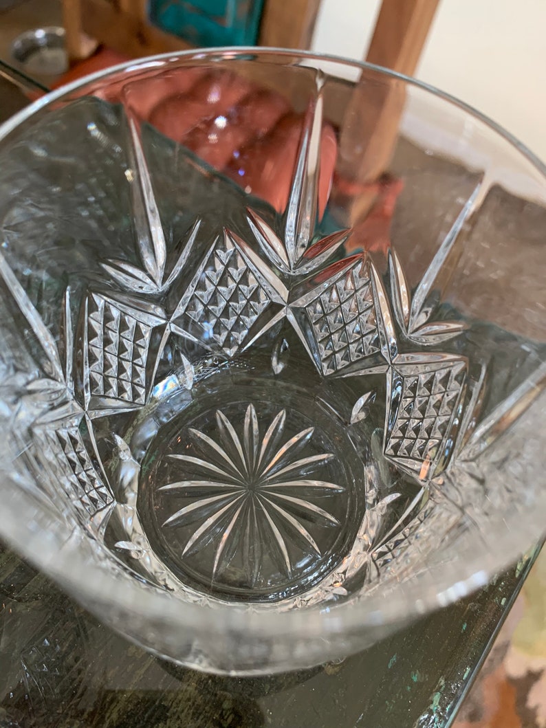 K&ouml;nnte beinhalten: Ein klares Glas mit geschnittenem Kristallmuster. Der Boden des Glases hat ein Sternmuster.