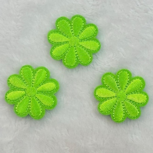 May include: Three bright lime green flower-shaped embroidered patches. Each patch features a central circular core surrounded by eight rounded petals with visible stitching detail along the edges, creating a textured, raised appearance.