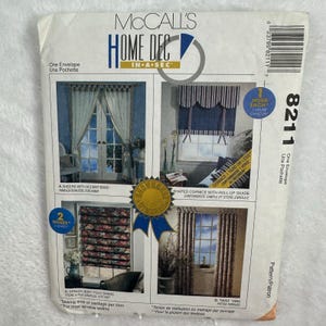 May include: A McCall's Home Dec pattern envelope showing four window treatment designs. The envelope features images of sheers, a shaped cornice, a soft fold shade, and twist tabs. The text includes "One Envelope" and the number "8211".