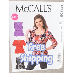 May include: McCall's M7205 sewing pattern envelope featuring illustrations of three top variations: a sleeveless purple wrap top, a short-sleeved orange wrap top, and a black and white patterned wrap top. The envelope includes size range RR.