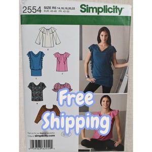 May include: Simplicity sewing pattern 2554 for tops in sizes R5 14, 16, 18, 20, 22. The package displays illustrations of various blouse designs with ruffled sleeves and necklines, alongside photographs of models wearing a blue and a pink version of the top.