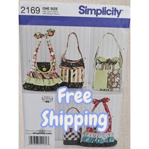 Puede incluir: Un sobre de patrón de costura Simplicity, número 2169, que muestra ilustraciones de varios bolsos de tela hechos a mano. Los diseños incluyen bolsos con capas de volantes, correas de lunares, paneles a rayas y estampados florales.