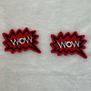 May include: Two red embroidered patches in a speech bubble shape with black outlines. The word "WOW" is embroidered in white block letters on each patch. The patches are on a white background.