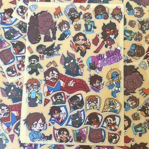 Könnte beinhalten: Ein Bogen mit bunten Aufklebern mit verschiedenen Cartoon-Charakteren in verschiedenen Posen. Die Aufkleber haben einen gelben Hintergrund und enthalten den Text "YOU BLIND ME FOREVER". Die Aufkleber sind in verschiedenen Formen und Größen.