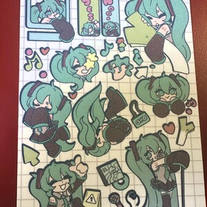 May include: A sheet of stickers featuring various illustrations of a teal-haired anime character. The stickers include images of the character in different poses, with musical notes, hearts, and other decorative elements. The stickers are on a grid-lined background.