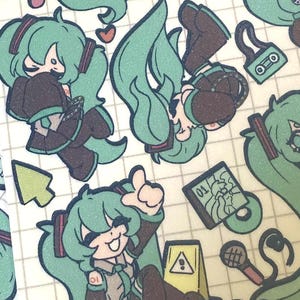 May include: A sheet of stickers featuring a cartoon character with long, teal hair and brown clothing. The stickers include various poses of the character, along with other small illustrations like a cursor, a cassette tape, and a microphone.