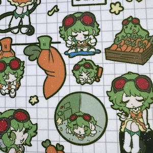 May include: A sticker sheet featuring a grid pattern background with multiple illustrations of a green-haired character wearing red goggles. The character is depicted in various poses, including crying, sitting, and interacting with orange carrots.