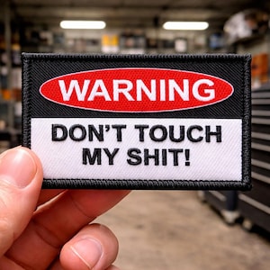 May include: Embroidered patch with a black border, featuring a red oval with the white word "WARNING" above a white rectangle with the black text "DON'T TOUCH MY SHIT!"
