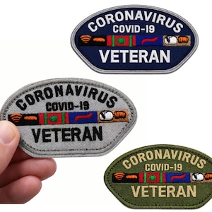 May include: Three embroidered patches with the text "CORONAVIRUS COVID-19 VETERAN". The patches are in blue, gray, and olive green, with a central design of a ribbon and symbols. The patches are oval and shield-shaped.