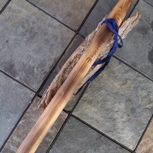 May include: A wooden staff with a blue cord tied around it. The staff is engraved with the words "Kentucky" and "Craftsman".