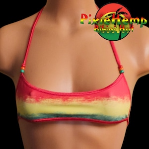 May include: A red and yellow bikini top with a halter neck design. The top features a color gradient of red, yellow, and green. The straps are thin and adorned with small beads. The logo "Pixie Hemp Bikini Hut" is visible in the upper right corner.