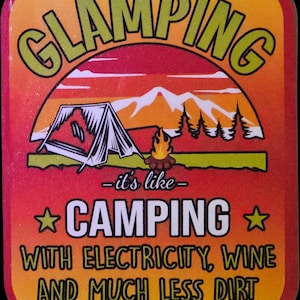 May include: A rectangular sign with the word "GLAMPING" in green letters. The sign features a camping scene with a tent, mountains, and a campfire. The text "it's like CAMPING with electricity, wine, and much less dirt" is also included.