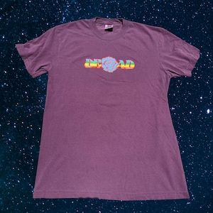 May include: A purple t-shirt with a rainbow colored graphic of the word "DEAD" with a blue rose in the middle of the word.