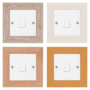 May include: Four light switch covers in different wood finishes: light brown, white, medium brown, and orange. Each cover has a white light switch with a toggle.