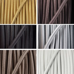 May include: Close-up of six different colours of fabric-covered electrical cords. The colours are gold, brown, black, silver, brown, and white.