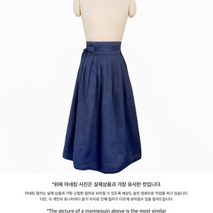 Puede incluir: Un maniqu&iacute; lleva una falda larga, plisada, de color azul oscuro. La falda est&aacute; atada a la cintura con una faja de tela a juego. La imagen del maniqu&iacute; es la m&aacute;s similar al producto real. El color puede verse diferente debido al brillo de cada monitor individual.