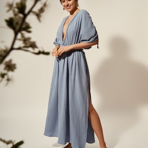 K&ouml;nnte beinhalten: Ein hellblaues Maxikleid mit tiefem V-Ausschnitt und einem Schlitz an der Seite. Das Kleid hat eine lockere Passform und ist aus einem weichen, leichten Stoff gefertigt.