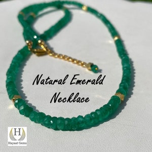 May include: A green emerald gemstone necklace with a gold clasp and gold accents. The necklace is made of natural emeralds and is called "Natural Emerald Necklace".