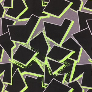 Könnte beinhalten: Abstrakter geometrischer Musterstoff mit schwarzen, grauen und neongrünen Formen. Der Stoff hat eine strukturierte, gebürstete Optik.