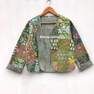 Op de afbeelding: Een groen gewatteerd jack met een bloemenprint en gestreepte voering. Het jack heeft een V-hals en lange mouwen.