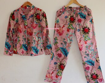 May include: A pink pajama set with a floral print. The top has a collar and long sleeves. The pants have an elastic waistband.