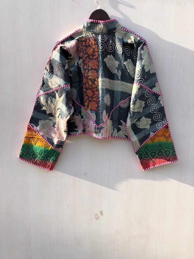 Puede incluir: Chaqueta patchwork con cuello alzado, con estampados florales y geom&eacute;tricos en azul marino, naranja y crema. La chaqueta tiene un dise&ntilde;o corto con detalles arco&iacute;ris en las mangas y est&aacute; ribeteada con costuras rosas.