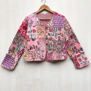 Peut inclure: Une veste matelassée rose à imprimé floral et fermeture boutonnée. La veste a un design patchwork et est en coton.