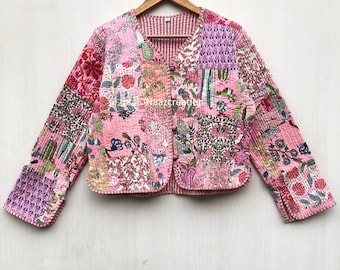 Op de afbeelding: Een roze gewatteerd jack met een bloemenprint en een knoopsluiting. Het jack heeft een patchwork-ontwerp en is gemaakt van katoen.