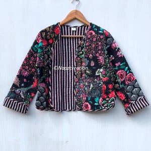May include: A black and pink floral print quilted jacket with a striped lining. The jacket has a V-neck and long sleeves.