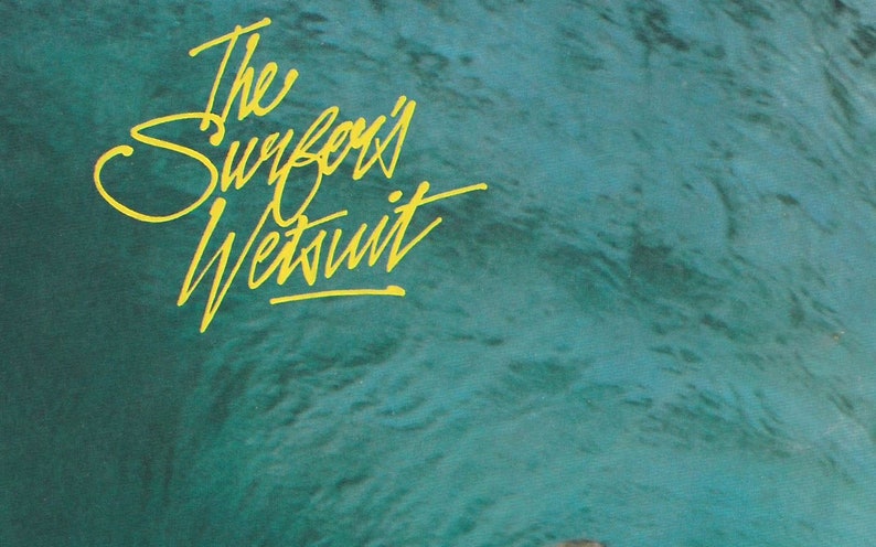 May include: The Surfari Wetsuit logo in yellow script on a teal blue background.