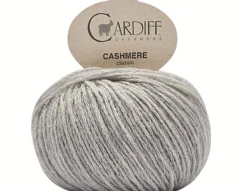 Puede incluir: Un ovillo de hilo de cachemira gris claro con una etiqueta marrón que dice "CARDIFF CASHMERE" y "CASHMERE classic".
