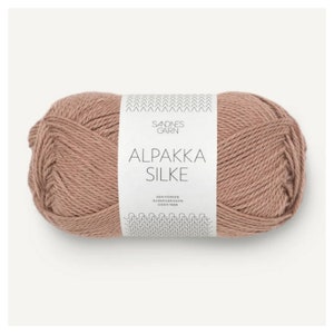 May include: A ball of brown Alpaca Silk yarn with a white label that reads "Sandnes Garn Alpakka Silke Den Norske Garnfabrikken Siden 1888".