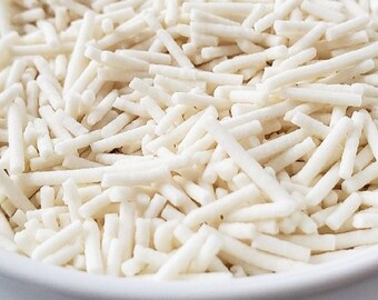 Könnte beinhalten: Eine weiße Schüssel gefüllt mit weißen, dünnen und langen Streuseln. Die Streusel haben die Form von kleinen, dünnen Stäbchen.