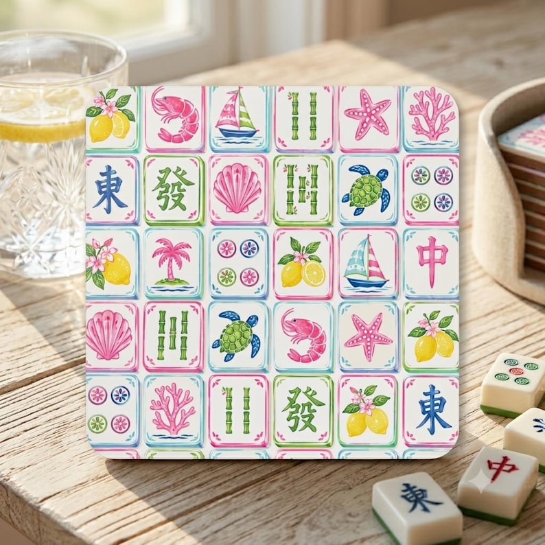 May include: A square coaster featuring a grid of colorful illustrations including pink shrimp, sailboats, green bamboo stalks, pink starfish, coral, sea turtles, seashells, lemons with blossoms, and blue Chinese characters on a white background.