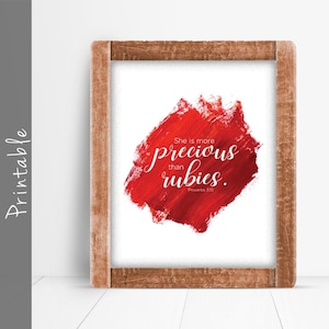 May include: Printable wall art with a red watercolor background and the text "She is more precious than rubies. Proverbs 3:15"