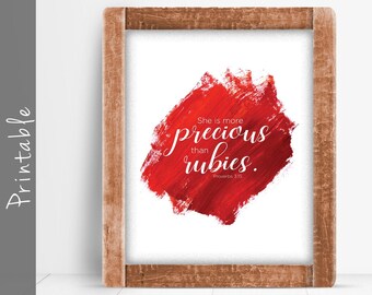 Pode incluir: Arte de parede imprimível com um fundo de aquarela vermelho e o texto "Ela é mais preciosa do que rubis. Provérbios 3:15"