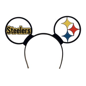 May include: Black headband with two circular Mickey Mouse ears. One ear features the word "Steelers" in gold lettering. The other ear displays the Steelers logo with yellow, red, and blue shapes.