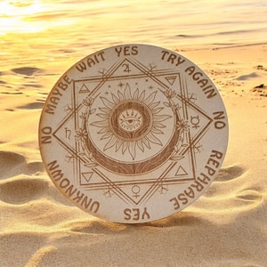 Può includere: Un vassoio circolare di legno con un disegno di sole e occhio al centro. Il vassoio ha le parole "Sì", "Riprova", "No", "Riformula", "Sconosciuto", "No Forse Aspetta", e "Sì" scritte intorno al bordo.