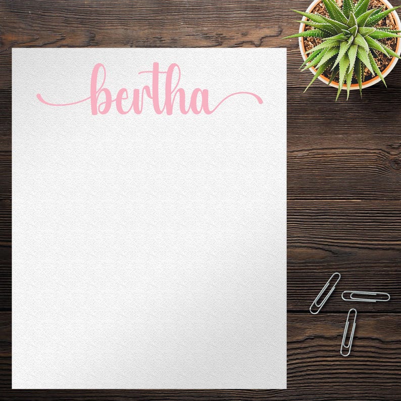 Pode incluir: Um bloco de notas branco com o nome "Bertha" escrito em letra cursiva rosa.