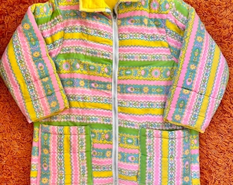 May include: A vintage quilted jacket with a yellow lining. The jacket has a floral pattern in shades of pink, green, and yellow.