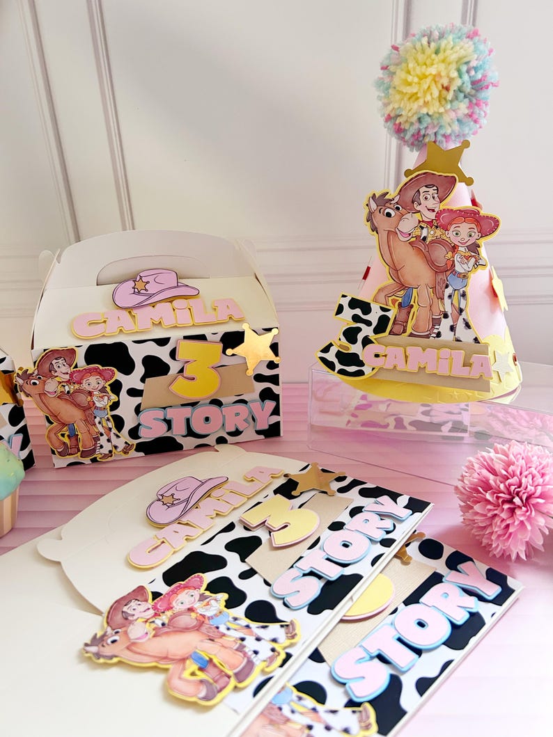 Peut inclure: D&eacute;corations de f&ecirc;te sur le th&egrave;me de la vache, avec les inscriptions "Camila" et "3 Story". Comprend un chapeau de f&ecirc;te avec un pompon, une bo&icirc;te cadeau et des d&eacute;coupes de carton avec des personnages de dessins anim&eacute;s.