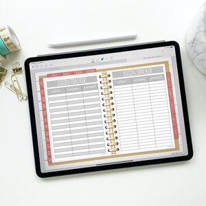 May include: A digital planner open to a page labeled "Login Tracker" with columns for website, username, and password. The planner has a brown cover and gold spiral binding.