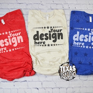 May include: Three t-shirts in red, cream, and blue, each with the text "Your design here" in a bold font. The red shirt has a star pattern, the cream shirt has a star pattern, and the blue shirt has a star pattern.