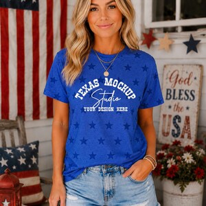 May include: A royal blue short-sleeve t-shirt featuring a repeating pattern of darker blue stars. The center of the shirt displays white text that reads TEXAS MOCHUP Studio YOUR DESIGN HERE in a mix of block and script fonts.