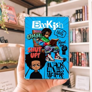 May include: A blue and black phone case with a cartoon illustration of a young person reading a book. The case has the words "Bookish", "Umm", "Shut Up", "Nope", "Read On", and "Black Lives Matter" printed on it.