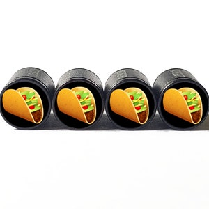 Op de afbeelding: Set van vier zwarte ventieldoppen met elk een kleurrijke taco-afbeelding.