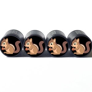 May include: Set of four black tyre valve stem caps with a cartoon image of a brown squirrel holding a nut.