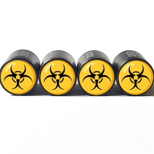 May include: Four black valve stem caps with a yellow biohazard symbol printed on the top.